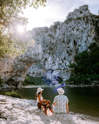 Rear view of people on rock against trees