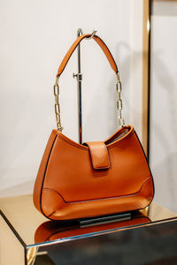 Bright orange leather women's handbag with gold chain. fashion details