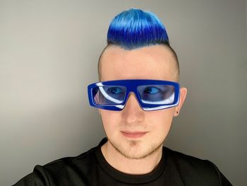 Portrait of young man wearing eyeglasses against white background