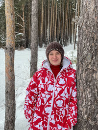 Portrait of smiling young woman standing in forest