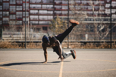 African man doing acrobatic activity on basketball court