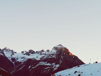 Low angle view of snowcapped mountains against clear sky