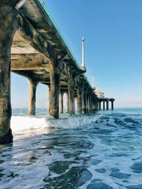 Low angle view of bridge over sea against clear sky