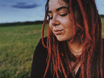 Portrait of a young woman with dreadlocks looking away