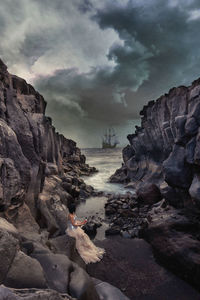 Rock formations on sea shore against sky