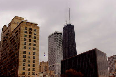 Low angle view of modern building against cloudy sky