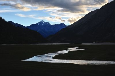 Scenic view of stream and lake against mountains