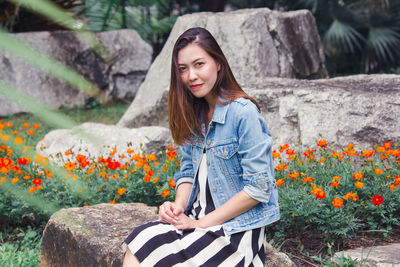 Portrait of beautiful young woman with red flowers