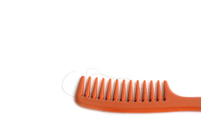 High angle view of orange colored pencils against white background