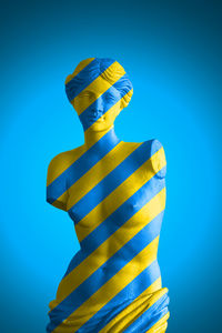 Digital composite image of statue against blue background