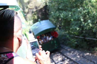 Midsection of man holding mobile phone