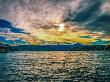 Scenic view of sea against dramatic sky during sunset