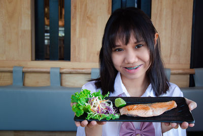 Portrait of a smiling girl holding food