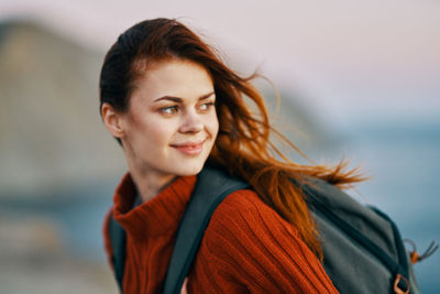 Portrait of smiling young woman looking away outdoors