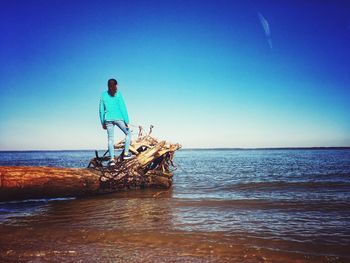 Man on beach against clear blue sky