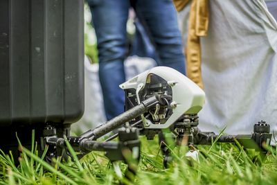 Low section of man standing by drone in back yard