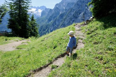 Rear view of child walking on austrian alps 