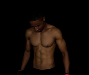 Young man looking away against black background