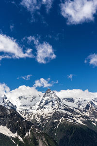 Scenic view of snowcapped mountains against blue sky