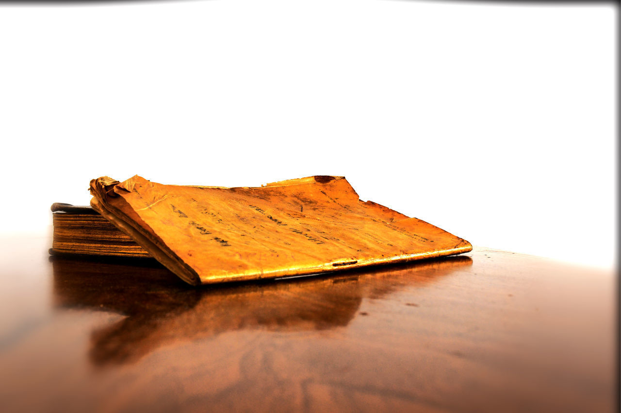 CLOSE-UP OF OPEN BOOK ON TABLE