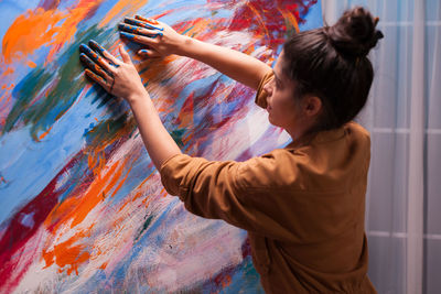 Woman painting with hands at home