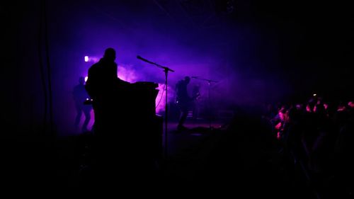 Silhouette of man playing in music concert