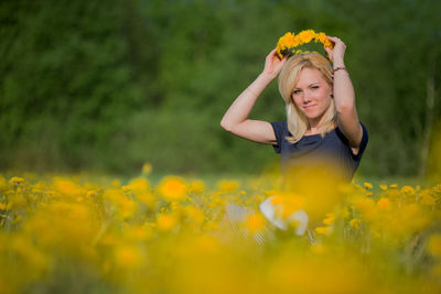 Portrait of young woman with yellow flowers