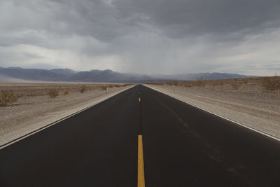 Road by landscape against sky