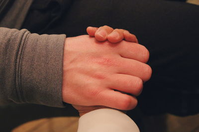 Close-up of cropped couple holding hands