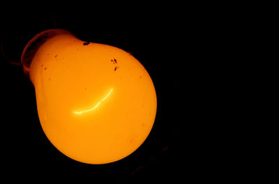 Close-up of yellow moon over black background