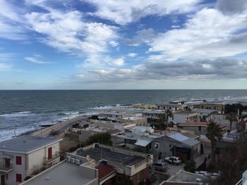 High angle view of town by sea against sky