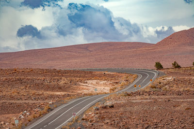Road amidst field against sky