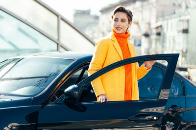 Side view of young woman holding car