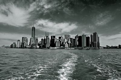 City buildings by river against sky