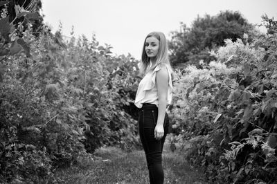 Portrait of woman standing against plants