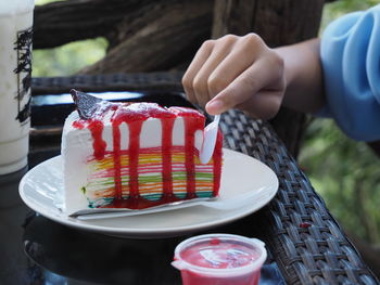 Midsection of person holding cake on table