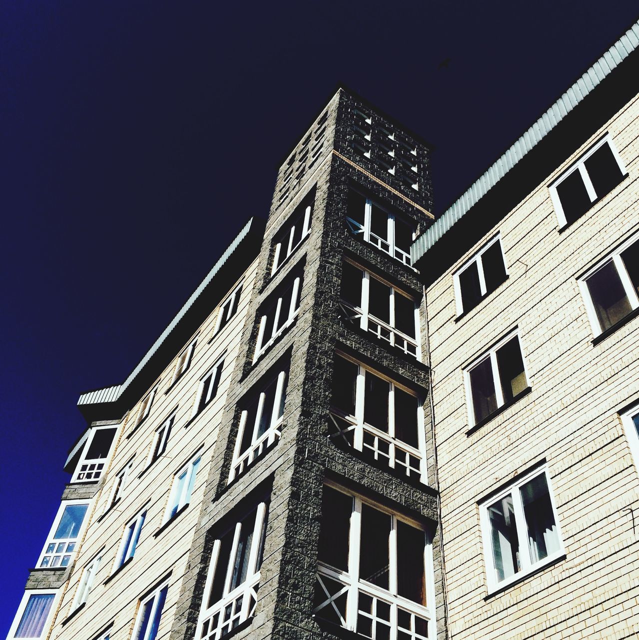 architecture, building exterior, built structure, low angle view, window, clear sky, building, city, residential building, residential structure, sky, apartment, outdoors, night, no people, facade, modern, brick wall, blue