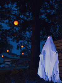 Low section of woman standing on field against sky at night