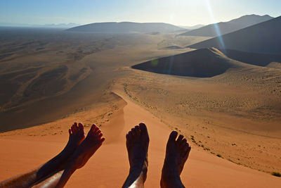 Couple's feet on sand dune