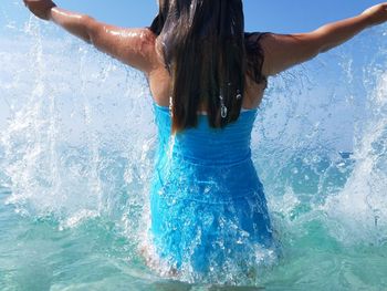 Rear view of woman standing in swimming pool