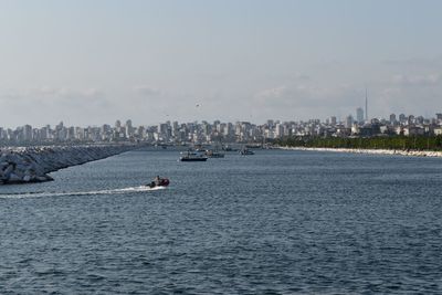 Scenic view of sea by buildings against sky