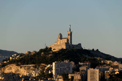 Buildings in city against clear sky