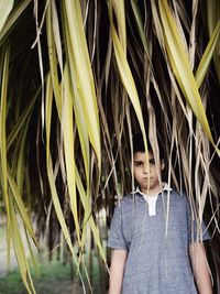 Portrait of boy standing amidst plants