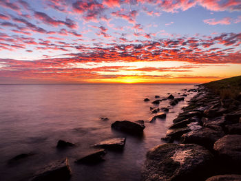 Scenic view of sea against romantic sky at sunset