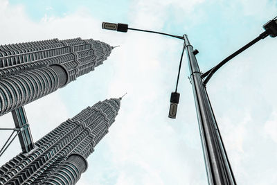 Low angle view of street light and petronas towers against sky