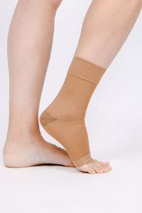 Low section of woman wearing socks against white background