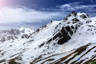 Scenic view of snowcapped mountains against cloudy sky