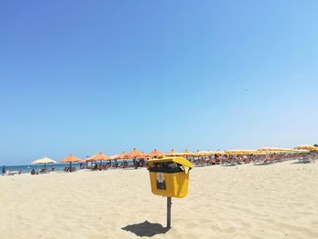 Lifeguard hut on beach against clear blue sky