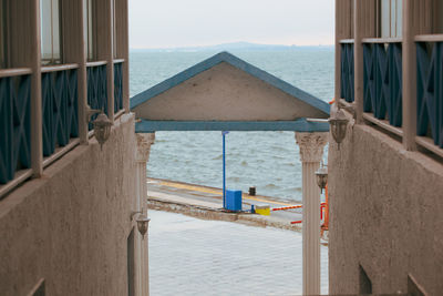 Beach hut by sea against sky