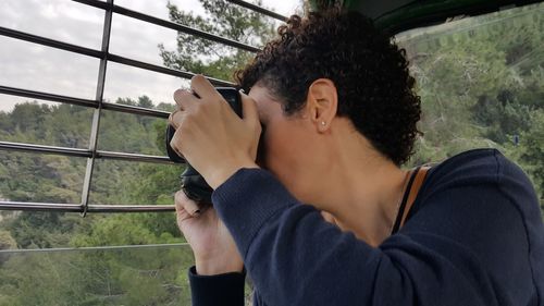 Midsection of woman using mobile phone against sky